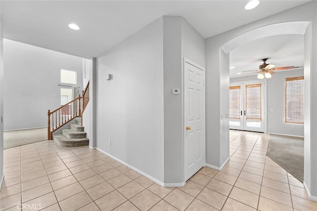 hallway featuring light tile patterned floors, baseboards, recessed lighting, and stairway