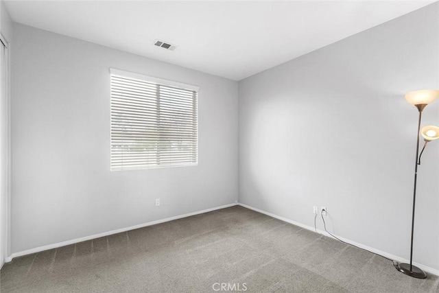 carpeted empty room featuring visible vents and baseboards