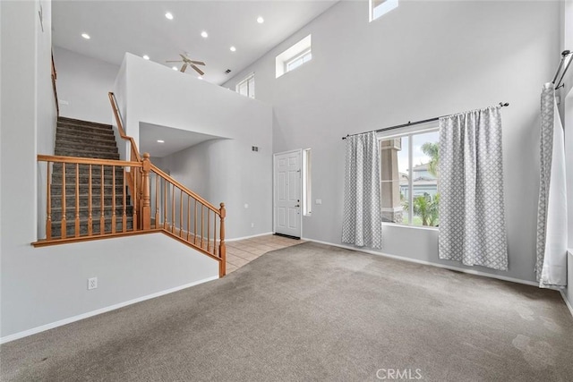 carpeted foyer entrance with baseboards, recessed lighting, stairway, a high ceiling, and a ceiling fan