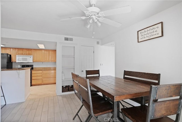 dining room with ceiling fan and light hardwood / wood-style flooring