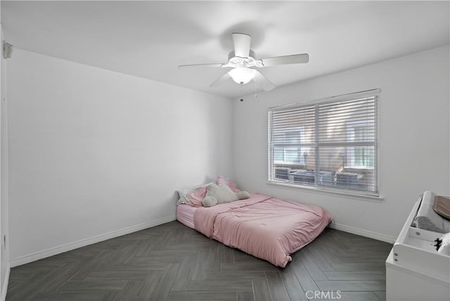 bedroom featuring ceiling fan and dark parquet floors