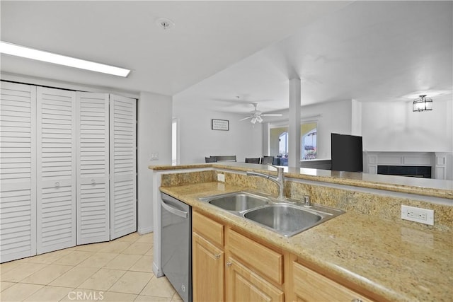 kitchen with sink, stainless steel dishwasher, ceiling fan, light tile patterned floors, and light brown cabinetry