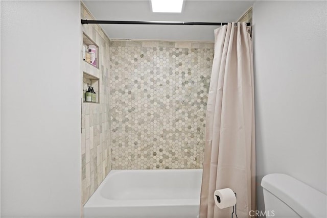 bathroom featuring shower / bath combination with curtain and toilet