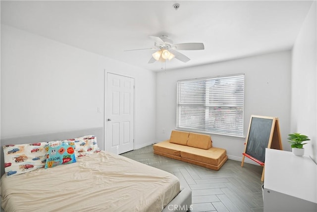 bedroom with ceiling fan and parquet flooring