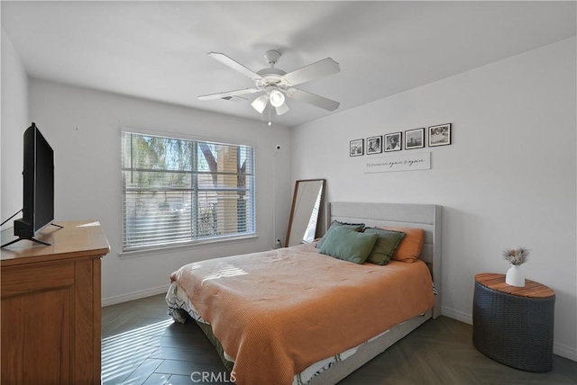 bedroom with ceiling fan and dark parquet flooring