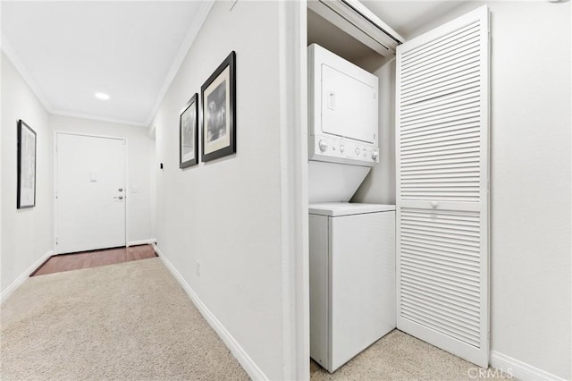 clothes washing area featuring stacked washer / drying machine, crown molding, and light carpet