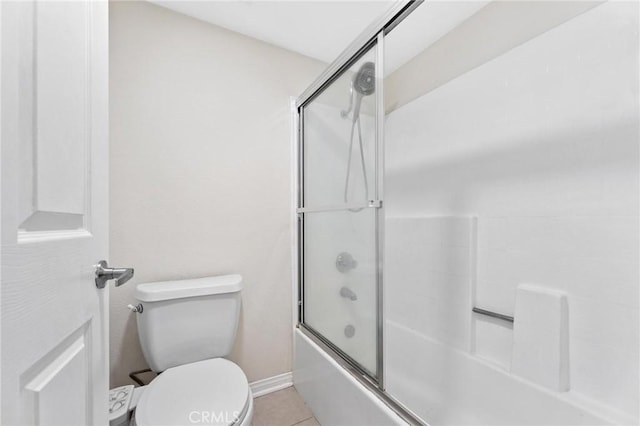 bathroom featuring tile patterned floors, toilet, and enclosed tub / shower combo