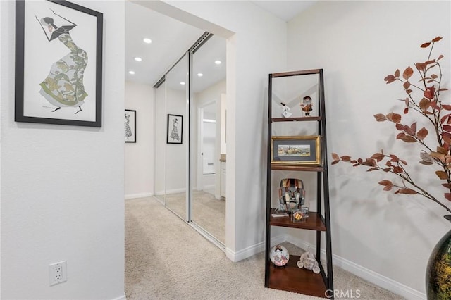 hall featuring light colored carpet