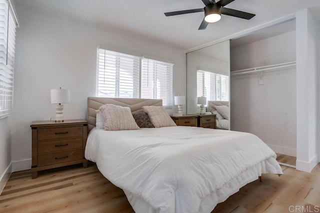 bedroom with light hardwood / wood-style flooring, ceiling fan, and a closet