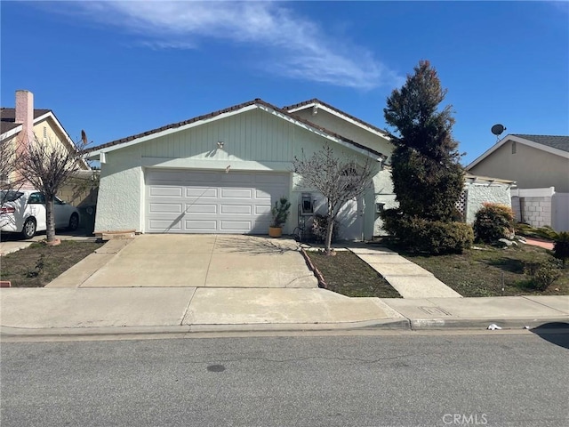 ranch-style house with an attached garage and concrete driveway