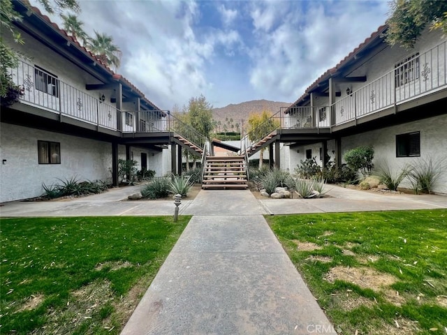 surrounding community with a yard and a mountain view