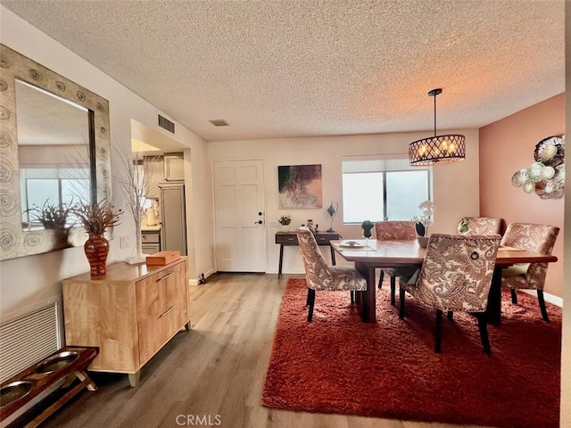 2230 S Palm Canyon Dr Unit 7, Palm Springs, CA 92264 - dining room with wood finished floors, a textured ceiling, and a chandelier