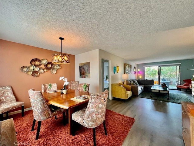 dining room with hardwood / wood-style floors, an inviting chandelier, and a textured ceiling