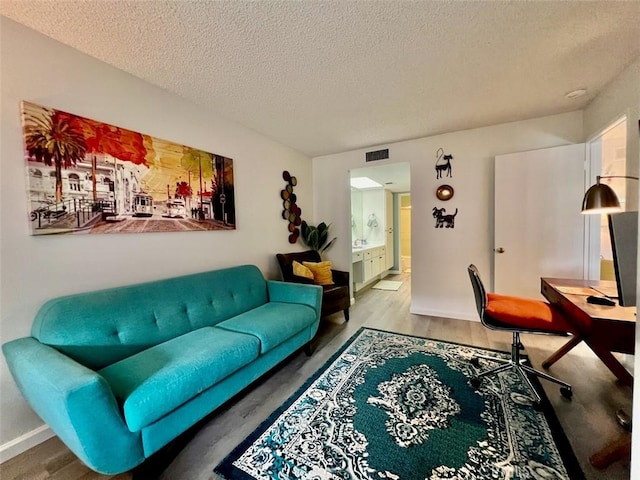 living room with a textured ceiling and hardwood / wood-style floors