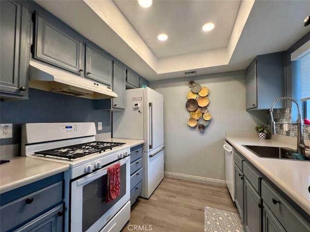 2230 S Palm Canyon Dr Unit 7, Palm Springs, CA 92264 - kitchen featuring white gas stove, under cabinet range hood, light wood-type flooring, light countertops, and a raised ceiling