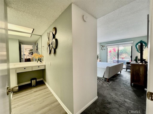 hallway featuring hardwood / wood-style flooring and a textured ceiling