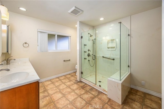 bathroom featuring vanity, toilet, and a shower with door