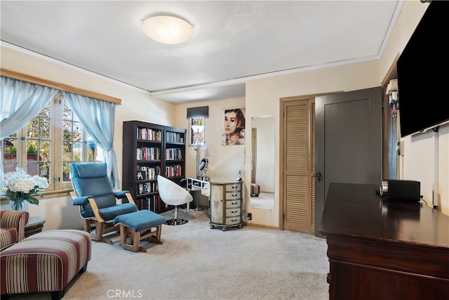 sitting room featuring ornamental molding and light carpet