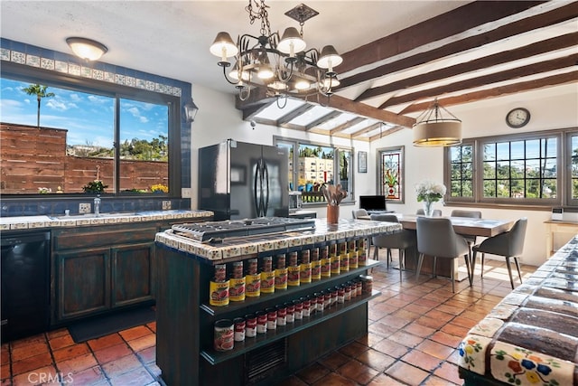 interior space featuring an inviting chandelier, sink, pendant lighting, lofted ceiling with beams, and black appliances