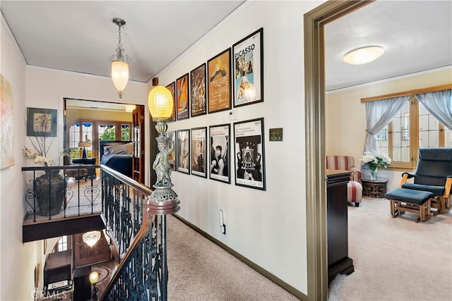 corridor with crown molding and light colored carpet