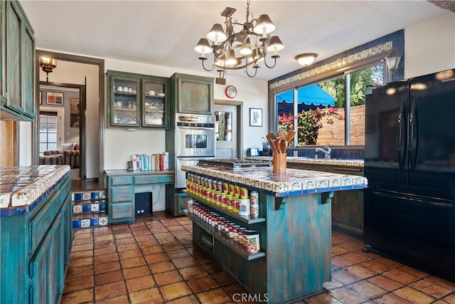 kitchen with an inviting chandelier, a breakfast bar, a center island, decorative light fixtures, and stainless steel appliances