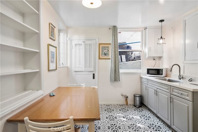 interior space featuring gray cabinets, sink, built in features, and decorative light fixtures