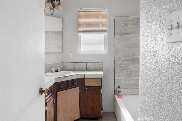 bathroom with tiled shower / bath combo and vanity