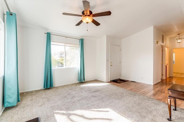 interior space with ceiling fan, carpet, and wood finished floors