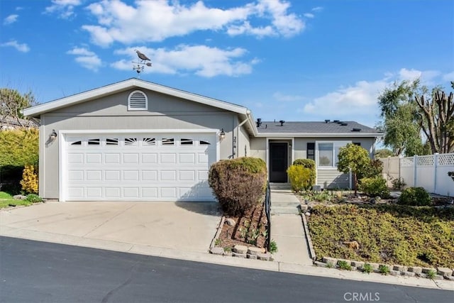 ranch-style house with an attached garage, driveway, and fence