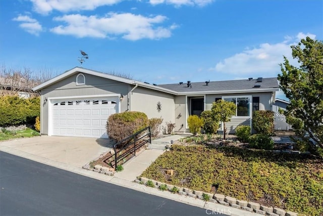 ranch-style home featuring a garage, driveway, and stucco siding