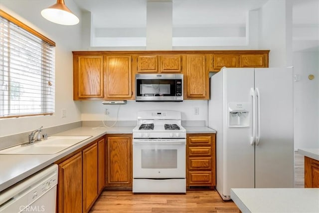 kitchen with white appliances, light countertops, and a sink