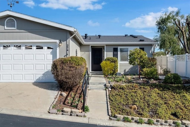 ranch-style house featuring a garage, fence, and concrete driveway