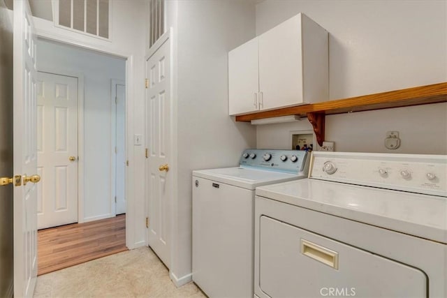 laundry room featuring visible vents, cabinet space, baseboards, and separate washer and dryer