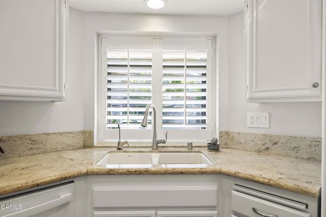 kitchen featuring white cabinets, dishwasher, light stone countertops, and sink