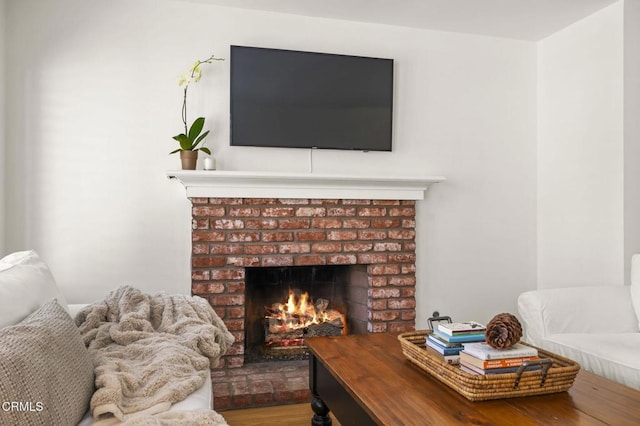 living room featuring hardwood / wood-style flooring and a brick fireplace