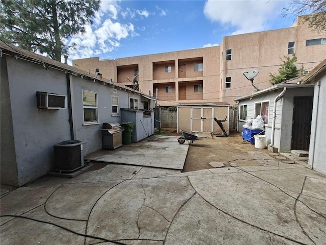 view of patio / terrace with a storage unit, grilling area, and central AC unit