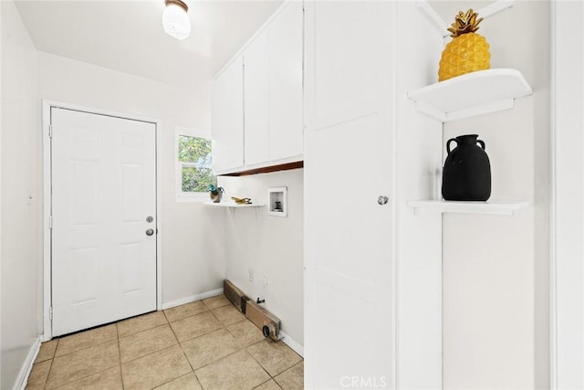 washroom featuring cabinet space, hookup for a washing machine, baseboards, and light tile patterned floors