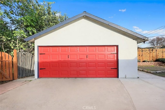 detached garage featuring fence