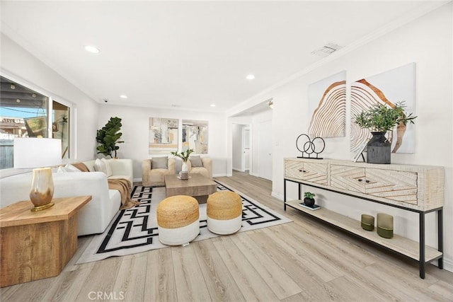 living room with recessed lighting, visible vents, crown molding, and light wood finished floors