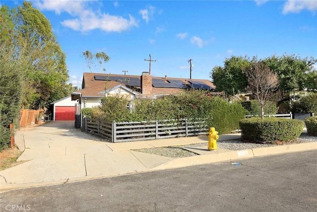 view of front facade with fence and solar panels