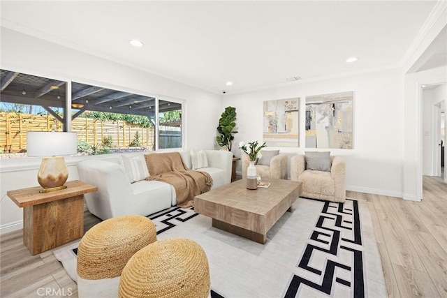 living room featuring ornamental molding, recessed lighting, baseboards, and light wood finished floors