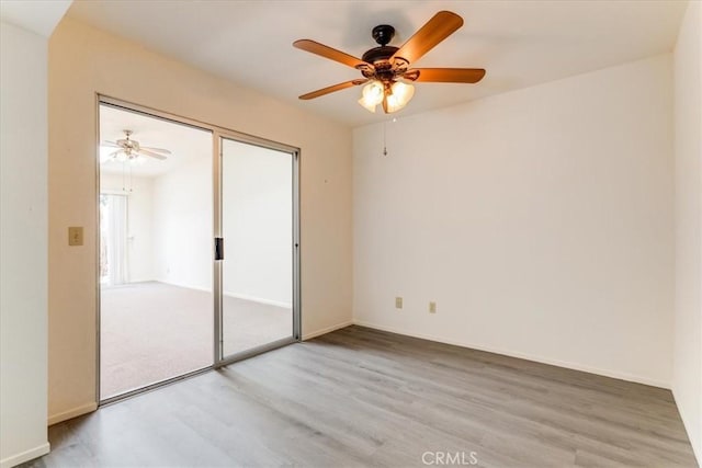 empty room with ceiling fan and light hardwood / wood-style flooring