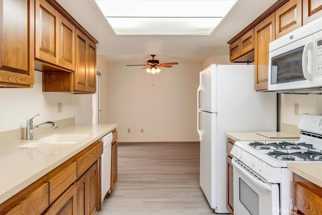 kitchen with ceiling fan, sink, white appliances, and light hardwood / wood-style floors