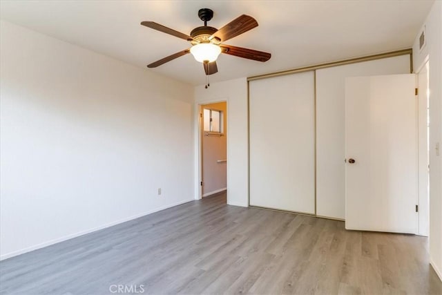 unfurnished bedroom with a closet, ceiling fan, and light hardwood / wood-style flooring