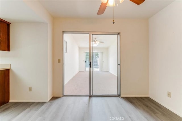 empty room with ceiling fan and light wood-type flooring