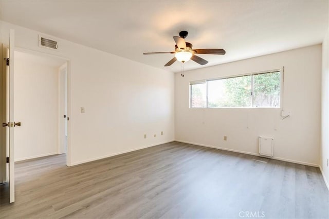 spare room with ceiling fan and light wood-type flooring