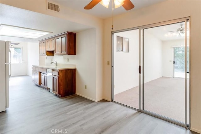 kitchen with white fridge, a healthy amount of sunlight, light hardwood / wood-style flooring, and ceiling fan