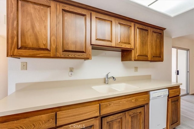 kitchen with light hardwood / wood-style floors, dishwasher, and sink