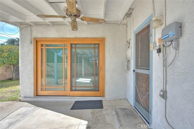 doorway to property with ceiling fan and a patio area