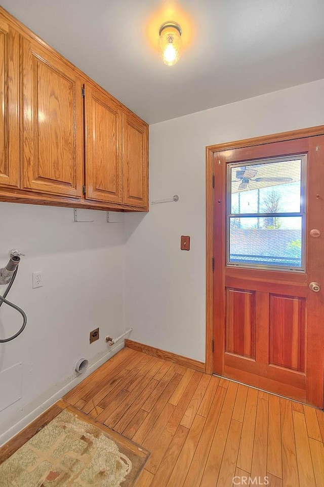 laundry area with light wood-type flooring, hookup for a gas dryer, cabinets, and washer hookup